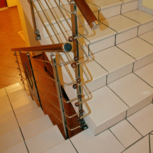 Ringhiera in acciaio inox per scala con pannelli in legno e vetro